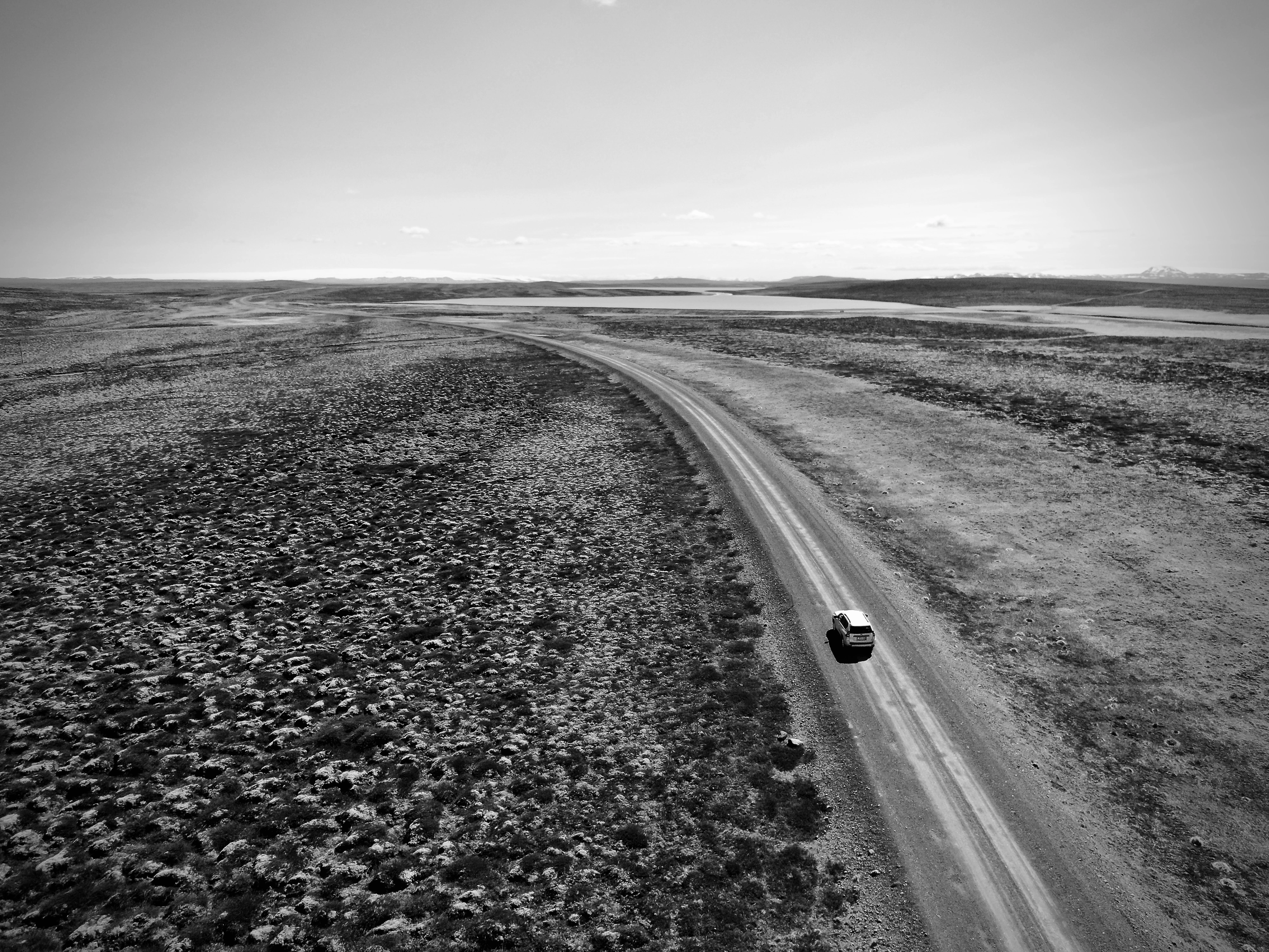 Car-driving-on-desert-road-alone-scaled