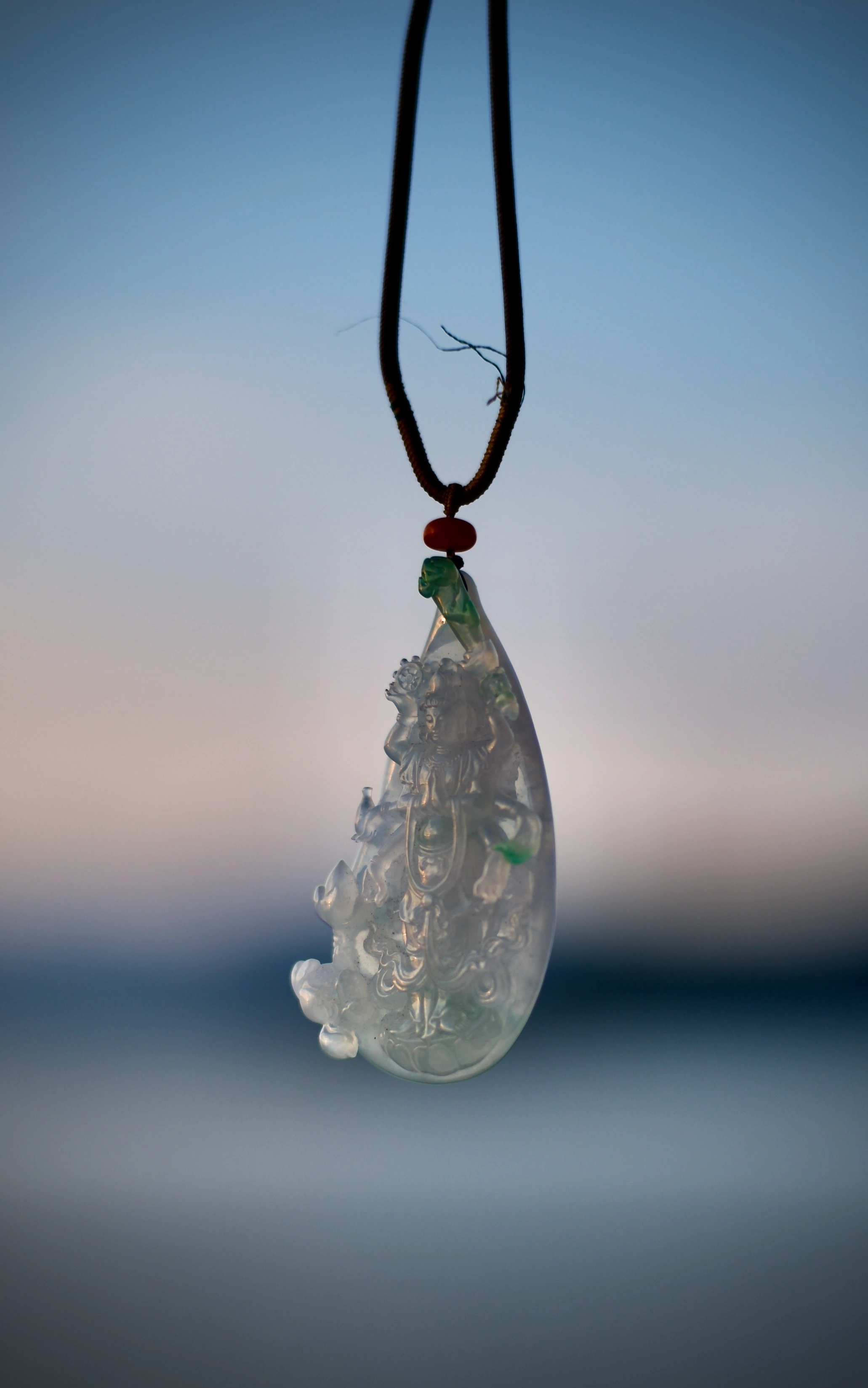 Carved-jade-pendant-hanging-in-daylight-1-scaled
