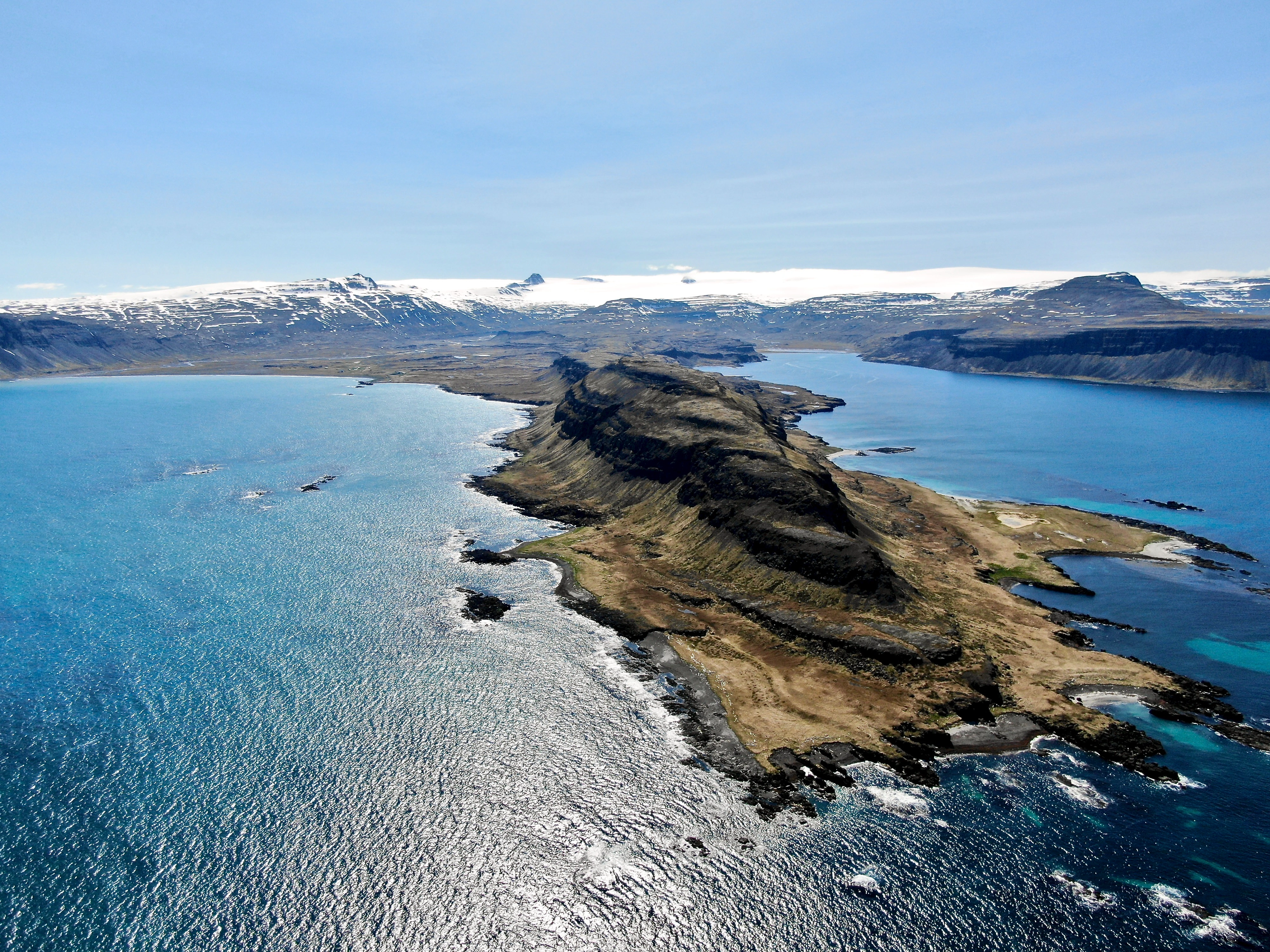 Rocky-peninsula-surrounded-by-blue-ocean-scaled