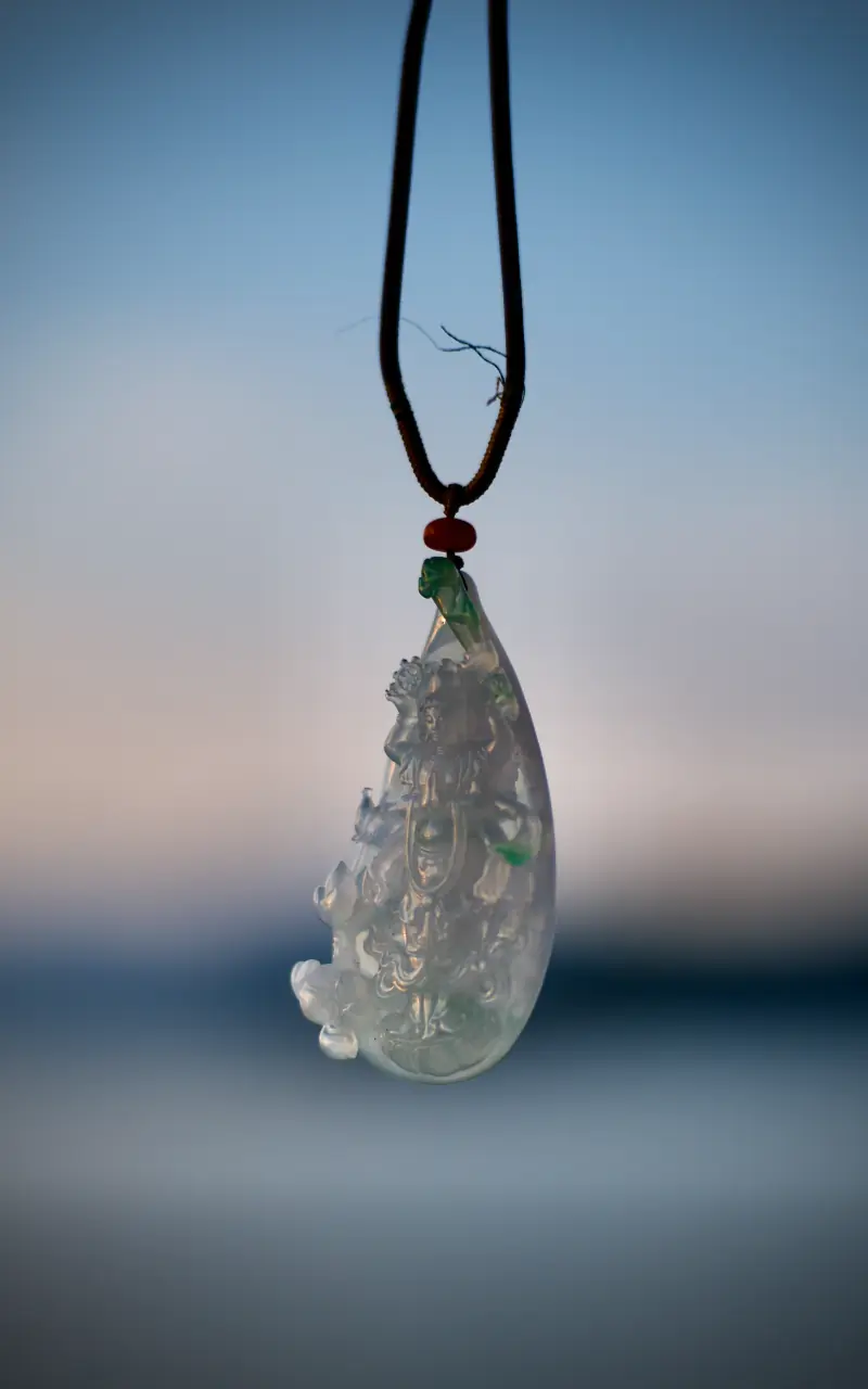 Carved-jade-pendant-hanging-in-daylight-1-scaled