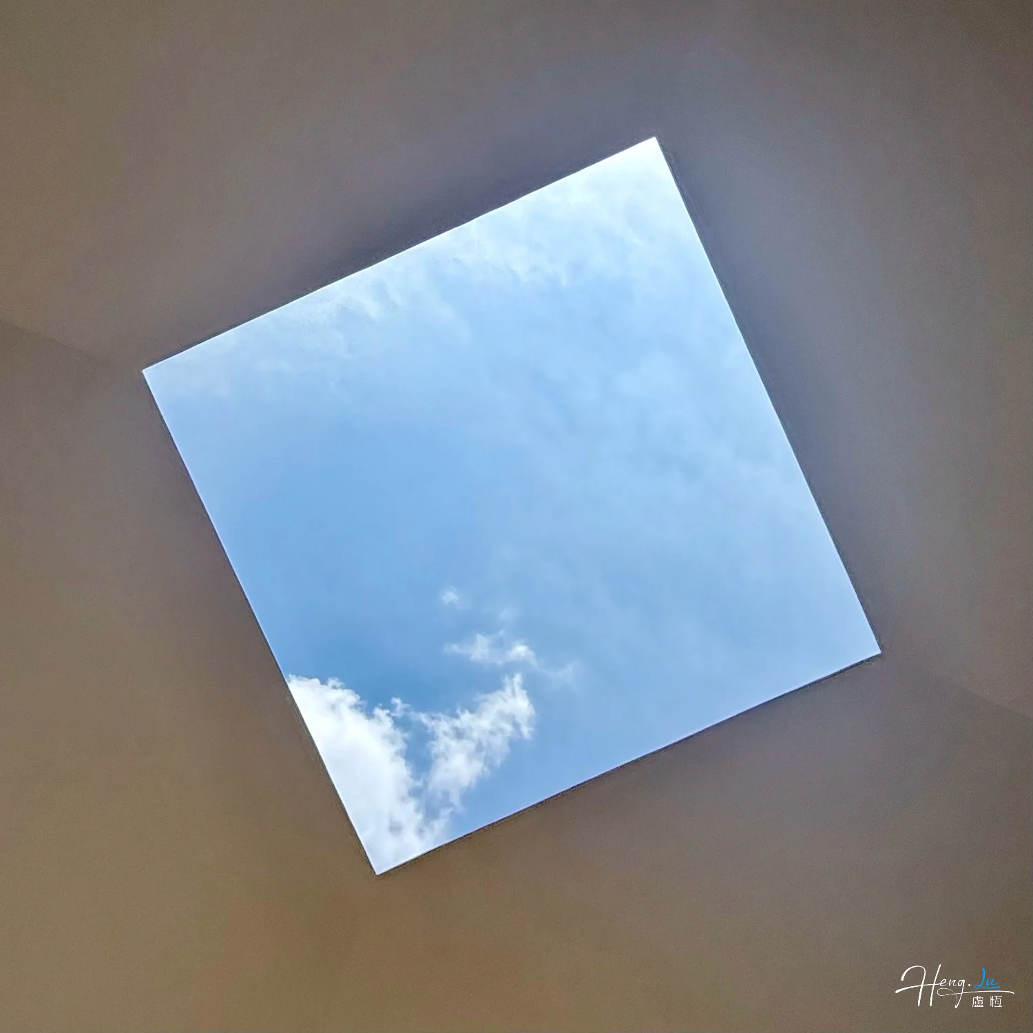 square-skylight-framing-blue-sky-and-white-clouds